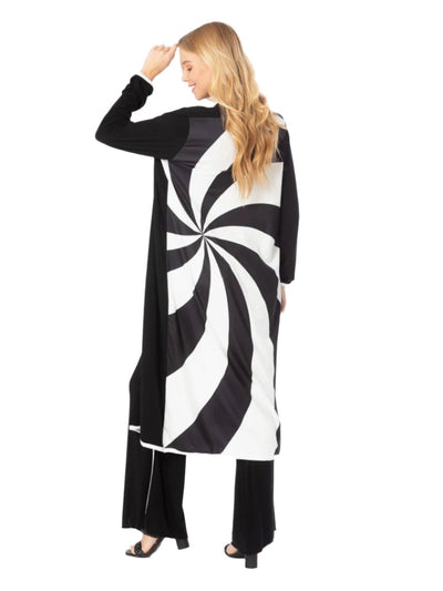 Woman wearing a black and white spiral patterned dress on a white background