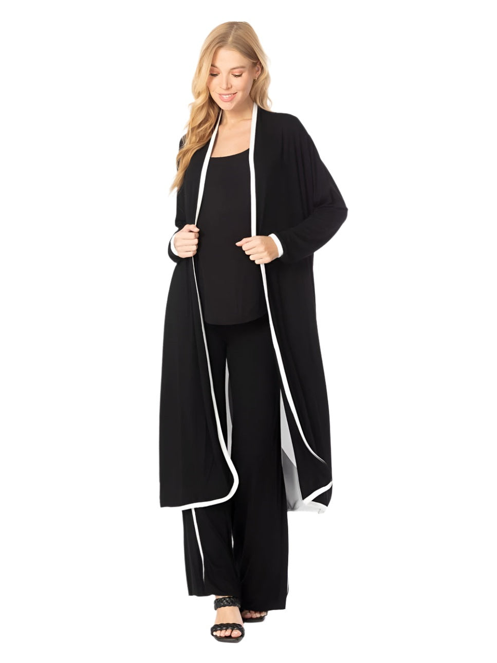 Woman wearing a black outfit with a long cardigan on a white background