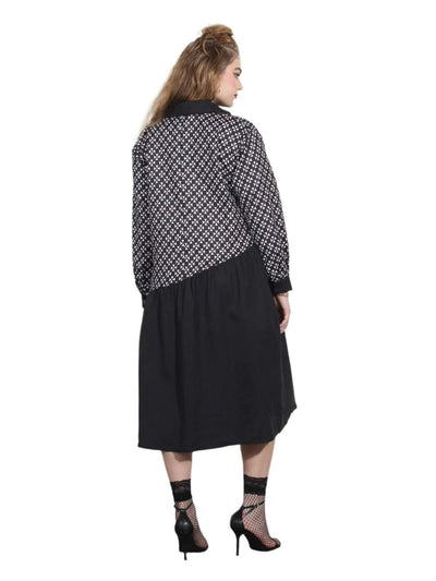 Woman wearing a black and white patterned shirt over a black dress.