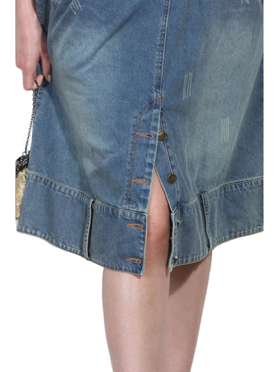 Denim skirt with a slit worn by a person against a white background